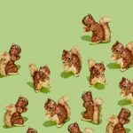 group of stuffed toy squirrels, clutching an acorn, facing in different directions