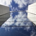 detail of building windows looking up with sky reflected