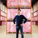 Jay Kleing standing in the Pur warehouse in fron of shelves of product