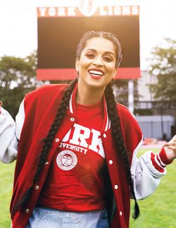 Lilly Singh standing in from of the York Lions sign at York University