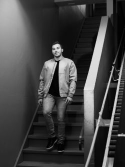 black and white portrait of Kaleb Dahlgren walking down flight of stairs