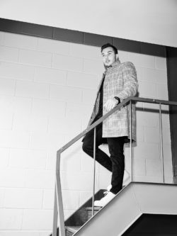 black and white portrait of Kaleb Dahlgren walking down stairs