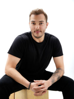 Kaleb Dahlgren seated on wooden crate smiling