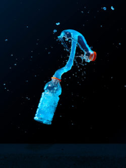 blue liquid exploding from sports drink bottle