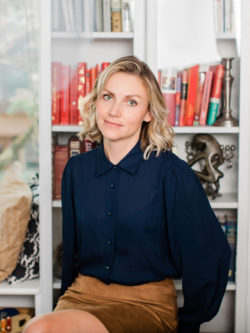 Eva Jurczyk, seated in front of book shelves