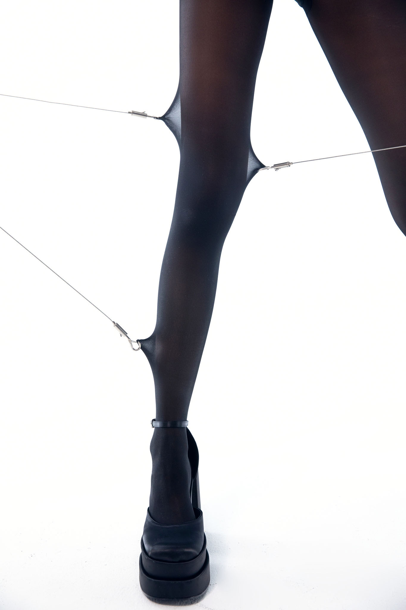 close-up of leg with Sheertex indestructible tights being pulled by clamps in 3 directions