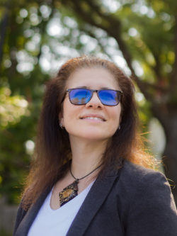 Adrina Bardekjian smiling looking up, standing in front of some trees
