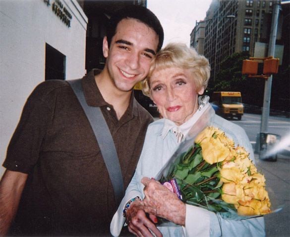 Ori Dagan hugging Anita O'Day, who carries a bouquet of yellow roses,  on a city street
