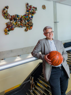 Sarah bay-Cheng leaning on railing in Accolade east holding a basketball