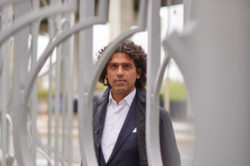 Usman Khan standing behind decorative metal work at Toronto's Bentway