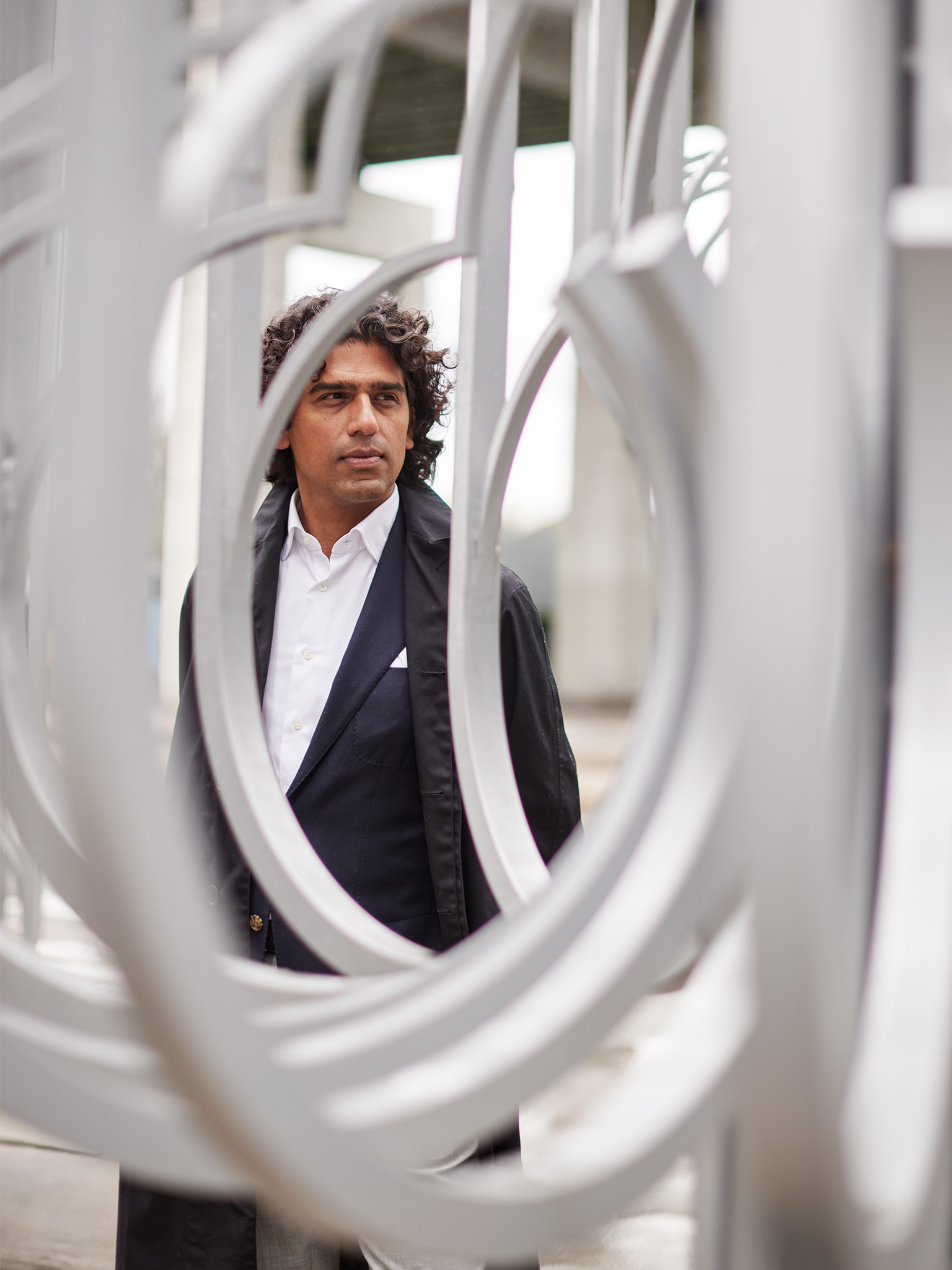 Usman Khan standing behind decorative metal work at Toronto's Bentway